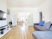 a living room with hardwood floors and a tv