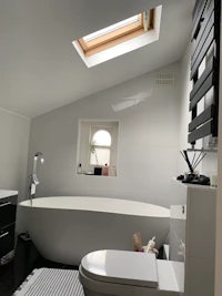 a black and white bathroom with a skylight