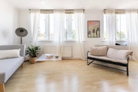 a living room with white walls and wooden floors